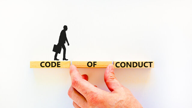 Code of conduct symbol. Concept words Code of conduct on wooden blocks on a beautiful white table white background. Businessman hand. Business and code of conduct concept. Copy space.