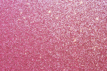 Pink sparkle glitter texture with golden particles as background