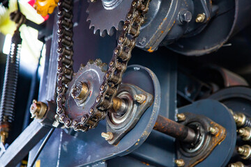 Close-up of chain drive of farm harvester machine. oily parts, sprocket and chain.