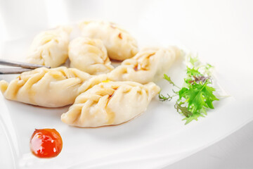 Steamed dumplings and soy sauce. asian dumplings Gyoza potstickers in white ceramic plate served with chopsticks over linen table cloth. Asian dinner