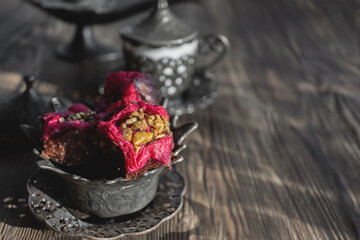 Baklava dessert with fried peanuts made of puff pastry in the shape of a beautiful flower with a cup of Turkish coffee. Still life in Arabic style. Oriental sweets close-up.