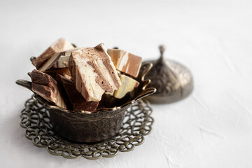 plate with halva made of sunflower seeds on a bronze tray, selective focus. Still life with halva in Arabic style.