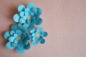 blue paper flowers on a light background. the decor is handmade.