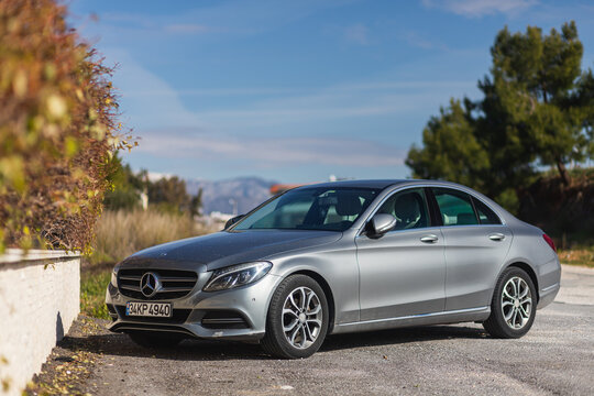 Side, Turkey -January 28, 2022: silver  Mercedes-Benz C-class is parked  on the street on a warm  day against the backdrop of a buildung, trees