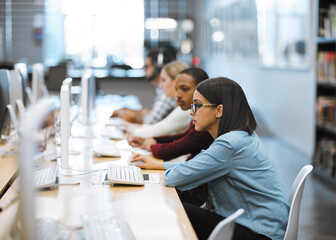 Working hard to complete all their assignments. Shot of a group of university students working on...