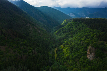 Mountains in Borjomi in summer aerial view. Beautiful green mountains with forest and sky with clouds in Georgia. The texture of a green summer mountain forest