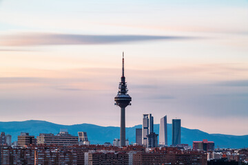 Naklejka premium Skyline of Madrid at dusk as seen from Cerro del Tio Pio, with the TV Tower and the skyscrapers along Castellana to be recognised. Long exposure.