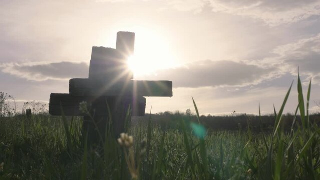 Two wooden christian cross in cemetery, sun rays shine behind, green grass, love after death, past and future, conceptual, hope