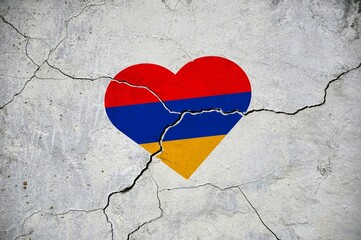 The symbol of the national flag of Armenia in the form of a heart on a cracked concrete wall.