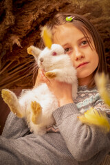 Fototapeta na wymiar Easter portrait of happy young beautiful girl with little rabbit. Vertical image.