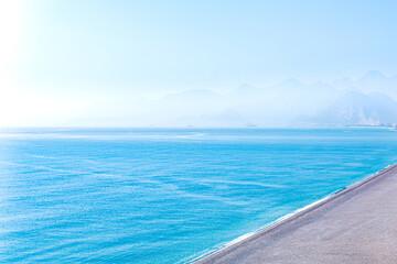 Fototapeta na wymiar seascape with deserted beach and mountainous shore far away in haze, aerial view