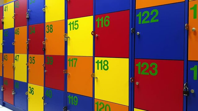 Multicolor school lockers, jump cut. Storage for things. Elementary school inside. Safety boxes with personal numbers. Concept of property protection. School atmosphere.