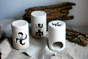 Ceramic white candlesticks on the table with tree bark
