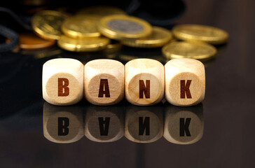 On a black surface are coins and cubes with the inscription - BANK