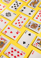 Top view of playing cards on a yellow background. Isometric layout design. Gambling mood. Flat lay minimal concept.