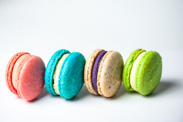 Colorful macarons cake, top view flat lay, fly falling sweet macaroon on color white isolated background. Minimal concepts falling macaroons pattern above, food natural background