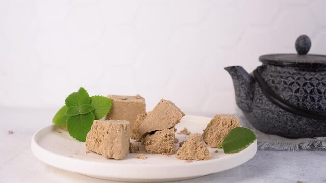 Traditional eastern dessert halva with sunflower seeds and mint on a white plate
