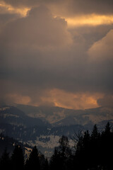 Amazing sunset. Winter forest. High mountains with snow white peaks.  Location place Carpathian, Vatra Dornei, Bucovina, Suceava, Romania, Europe.