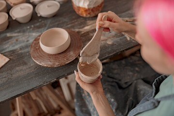 Fototapeta na wymiar Female potter master working on craft in clay studio