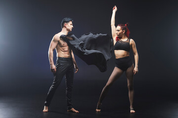 Circus acrobats man and woman showing tricks isolated on black background