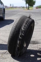 Worn wheel after drift on a blurred background of cars.