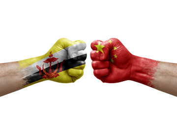 Two hands punch to each others on white background. Country flags painted fists, conflict crisis concept between brunei and china