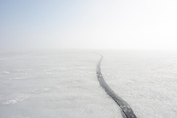 A dangerous crack in the ice of the frozen Gulf of Finland in winter. Russia, Saint-Petersburg