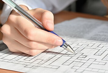the schoolgirl's hand is holding a pen. crossword puzzle