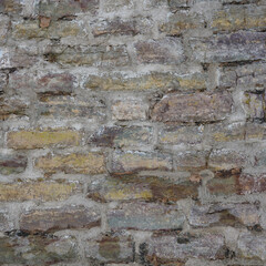A fragment of a wall made of multi-colored flagstone, stylized as antique.