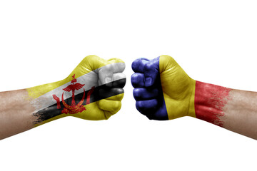 Two hands punch to each others on white background. Country flags painted fists, conflict crisis concept between brunei and romania