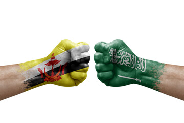 Two hands punch to each others on white background. Country flags painted fists, conflict crisis concept between brunei and saudi arabia