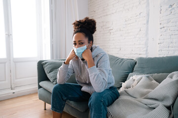 Young black woman wearing protective mask against COVID virus suffering from depression