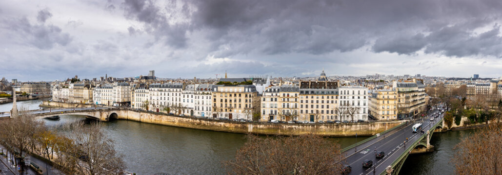 Seine embankment in Paris. View of the island  Saint-Louis, the bridge de la Tournelle and Sully Bridge. Beautiful breathtaking panoramic cityscape of the majestic famous ancient French city.