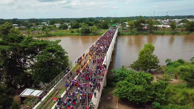 Una caravana de miles de migrantes de Honduras cruza el Puente Rodolfo Robles, un puente que pasa sobre el río Suchiate, una frontera natural de agua entre Guatemala y México, en octubre de 2018.