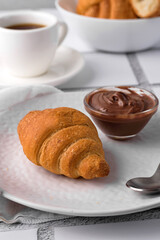 coffee and croissants, chocolate cream, french press on the table, morning breakfast 