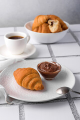 coffee and croissants, chocolate cream, french press on the table, morning breakfast 