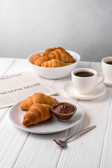 coffee and croissants, chocolate cream, french press on the table, morning breakfast 