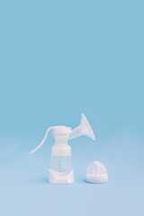 Breast pump and pacifier on a blue background. Breastfeeding concept. Vertical banner, copy space