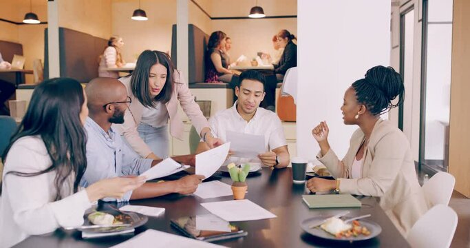Its amazing what you can achieve if you do not care who gets the credit. Group of young business people at a conference table in a modern office, talking and having lunch during a meeting