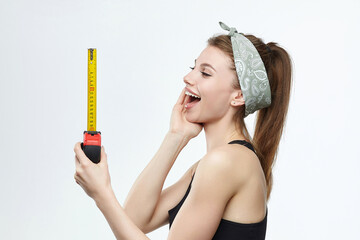 beautiful blonde girl holds a measuring tape in her hands. measurement concept about penis size - obrazy, fototapety, plakaty