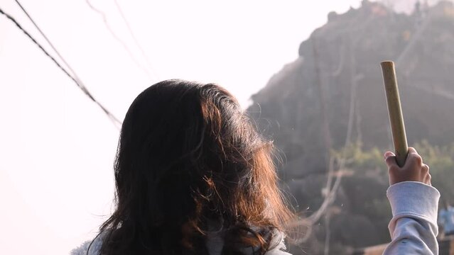 Indian Woman wearing white jacket posing in front of the Goarkhnath temple in top of Mount Girnar in Junagadh, Gujarat, India. Woman hiking on mountain.