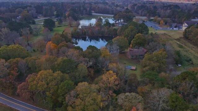Aerial up to view of 2 gorgeous fall lakes in country settings over a road
