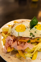 Fries with fried egg on a plate on a wooden table