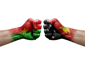 Two hands punch to each others on white background. Country flags painted fists, conflict crisis concept between burkina faso and papua new guinea