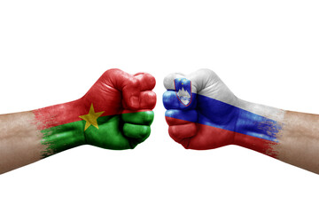 Two hands punch to each others on white background. Country flags painted fists, conflict crisis concept between burkina faso and slovenia