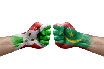 Two hands punch to each others on white background. Country flags painted fists, conflict crisis concept between burundi and mauritania