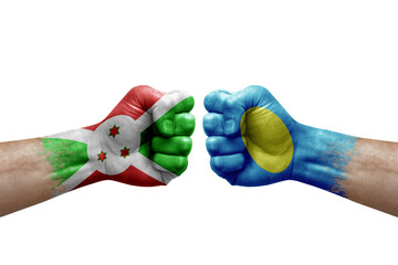 Two hands punch to each others on white background. Country flags painted fists, conflict crisis concept between burundi and palau