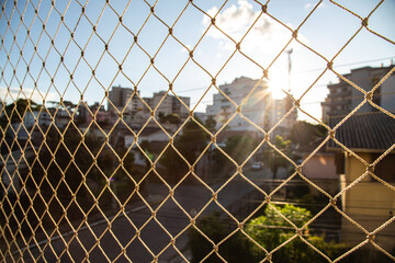 Safety nylon net for kids and pets on balcony with blurred city buildings in background
