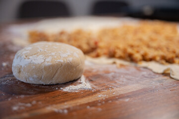 Ball of homemade vegan pastry dough resting on a flour dusted dinning table