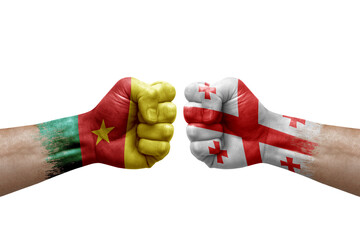 Two hands punch to each others on white background. Country flags painted fists, conflict crisis concept between cameroon and georgia
